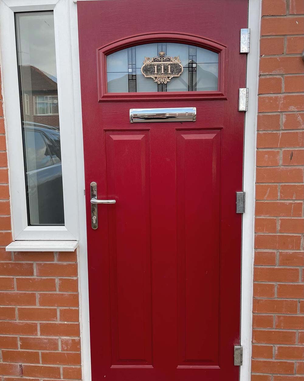 Red door with chrome handle and letter box