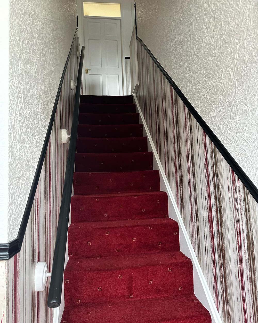 stairs of a house with striped pattern walls