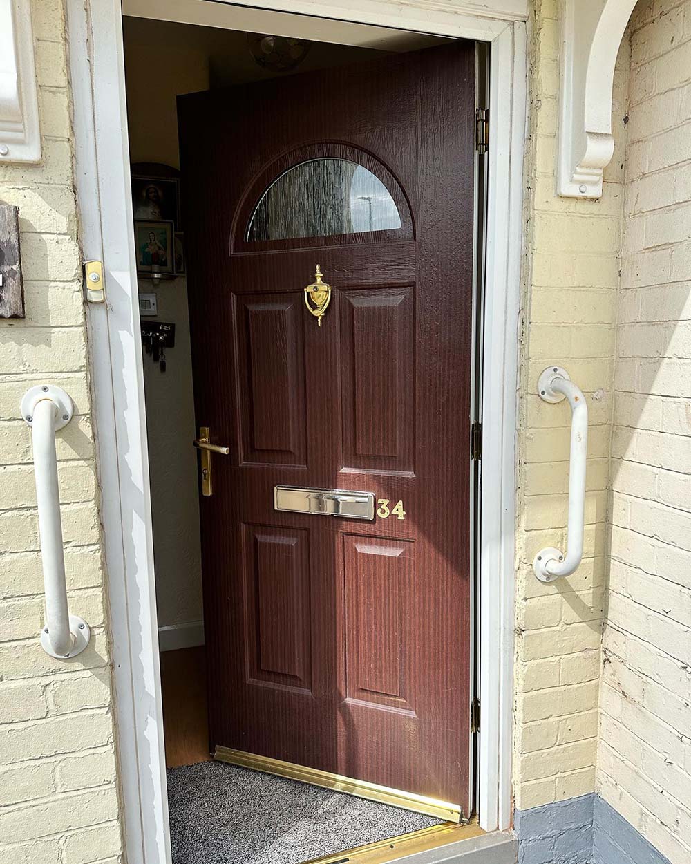 Old fashioned dark wood effect door with gold plated handle and knocker